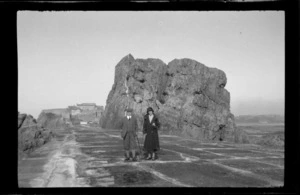 Unidentified man and woman on causeway, leading from town, Brittany, France