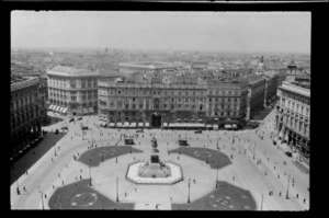 View over Piazza del Duomo showing Vittorio Emanuele II Statue and people walking in the square, including buildings in the distance, Milan, Italy