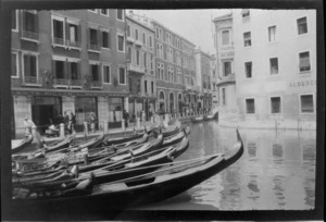 Group of gondolas moored in canal by walkway, Venice, Italy