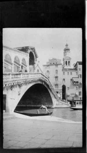 Gondolier with passenger under Bridge of Sighs, including buildings in the background, Venice, Italy