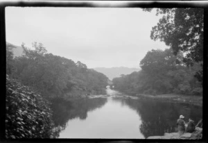 View of park reserve, including large pond and stream area with Lydia Williams and unidentified person by the rock's edge, Killarney, County Kerry, Ireland