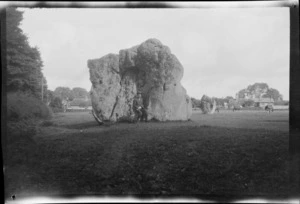 William Williams sitting on a neolithic standing stone, Avebury, Wiltshire, England