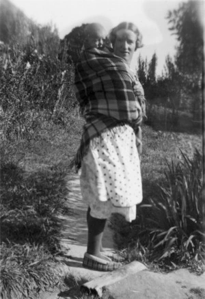 Photograph of Sylvia Ashton-Warner carrying her baby son Maori-style