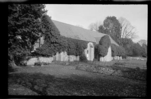 Stone church partially covered by creeper in country setting, [Devon], England