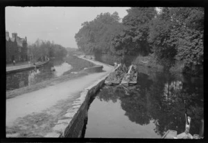 Long barges moored on river by unidentified town, [Buckinghamshire], England