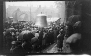 Large bell in centre of crowded square outside unidentified church, [Buckinghamshire], England