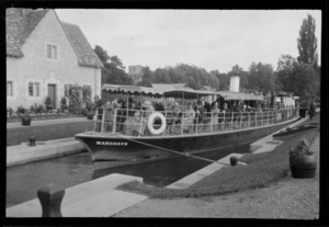 Passengers on the boat 'Wargrave', at an embarkation point on the Thames River with house and trees in background, taken between London and Oxford, England