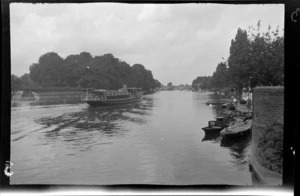 Passenger boat on River Thames, passing small boats moored, between London and Oxford, England