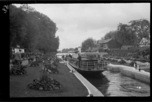 Passenger boat moored in lock, including gardens, lawns and houses, River Thames, south of Oxford, England