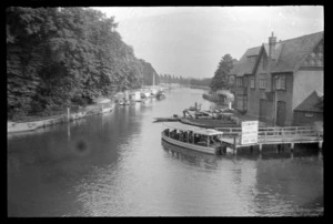 Passenger boat moored outside River Inn, with row boats, launch and boatsheds on the River Thames, between London and Oxford, England