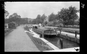 Passenger boat in lock with Lydia Williams seated and other passengers behind, including house and trees in the background, River Thames, between London and Oxford, England