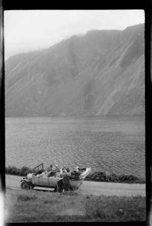 Charabanc, carrying fourteen passengers, by lake, including hills opposite, Lake District, England, United Kingdom