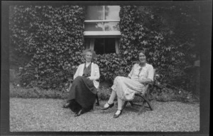 Two unidentified women, seated outside a vine covered house, Buckinghamshire, United Kingdom