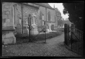 Graveyard next to church, including iron gates and cobblestone pathway, Buckinghamshire, England