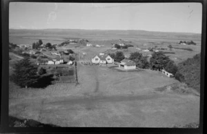 Elevated view of settlement near tidal flats, including school, [Kawhia, Waikato Region?]