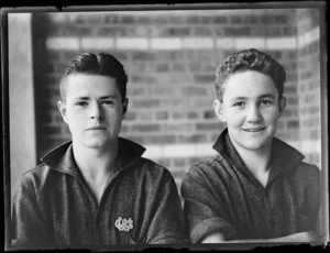 Portrait of two unidentified male secondary school students, one wearing a badge 'WTHS', at Westport Technical High School, West Coast Region