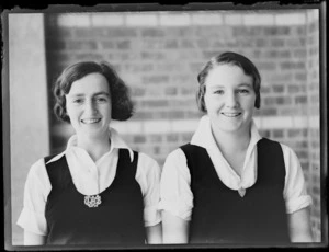 Portrait of two unidentified female secondary students, one wearing a badge 'WTHS', at Westport Technical High School, West Coast Region