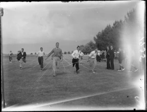 Young men, all unidentified, crossing finish line in a running race at a school sports day, at Westport Technical High School, West Coast Region