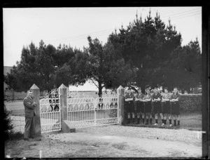 Edgar Williams and a group of male secondary students standing beside wrought iron gates, at Westport Technical High School, West Coast Region