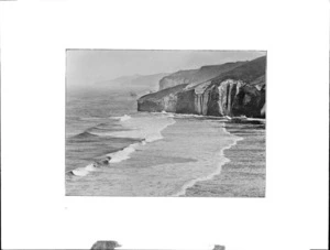 Coastal scene, showing steep cliffs and waves breaking onto shore, probably Otago Region