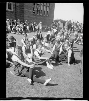 Group of unidentified girls sitting on grass at a school sports day, Westport Technical High School, West Coast Region