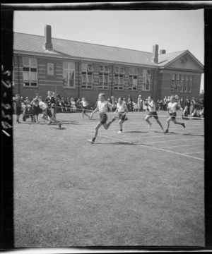 Boys' running race finish at a school sports day, showing field track beside a large brick building, Westport Technical High School, West Coast Region