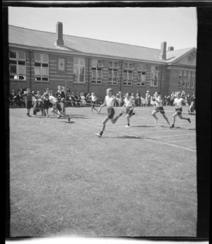 Boys' running race finish at a school sports day, showing track beside a large brick building, Westport Technical High School, West Coast Region