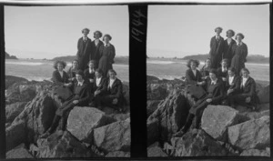 Group of unidentified schoolgirls from Westport Technical High School, standing on rocks at Cape Foulwind, Buller Buller District, West Coast Region, view of Tasman Sea beyond