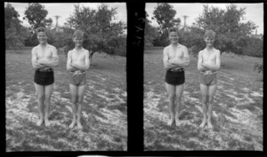 Two unidentified boys wearing swimsuits, standing on grass, location unidentified