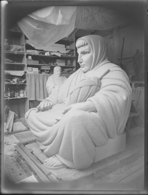 Sculpture of a woman holding a ball of yarn in artist's studio