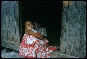 A small girl holding her baby brother, both unidentified, on Palmerston Island