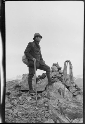 Jack Murrell standing next to a cairn on a mountain top, [Fiordland National Park?]