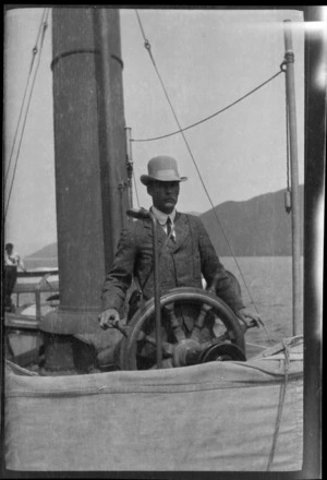 An unidentified man at a ships' wheel, [Lake Wakatipu or Lake Te Anau?]