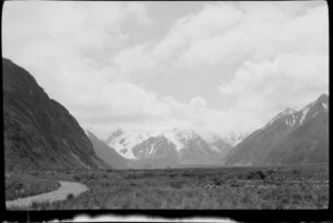 View across a mountain valley, with snowy range in background, [Canterbury, Otago or Southland?]