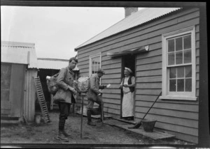 Edgar Williams and climbing companion, [Tracy Thomas Gough?] talking to another unidentified man [a cook?] outside a wooden building, Canterbury Region