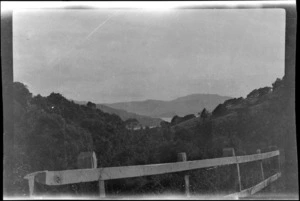 Fence, bush-clad hills, sea beyond, location unidentified