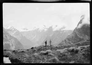 Two distant figures, William Grave and an unidentified woman, on Mackinnon Pass, Milford Track, with view of Clinton Canyon beyond, Southland District