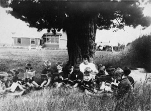 Teacher and children, reading outside