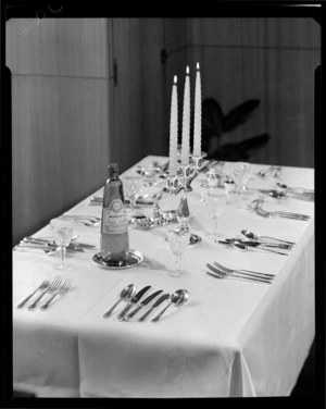 Table set with silver cutlery and bottle of wine