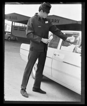 Mobil employee cleaning car window at ferry terminal