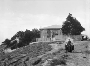 Woman and two boys, outside the house owned by William Moxham, on Upland Farm, Kelburn, Wellington