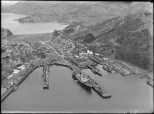 Port Chalmers township with residential and commercial buildings, and wharf area with ships and dry dock, Dunedin Harbour, Otago