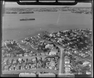 Devonport with residential housing, looking to Hobson Bay with an Aircraft Carrier entering the Waitemata Harbour, Auckland City
