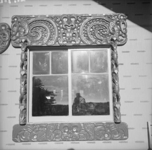 Maori wood carvings framing an exterior window of Tu Kaki meeting house at Te Kaha