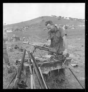 Soldier W R Bruce overhauling a machine gun, Italy, during World War 2