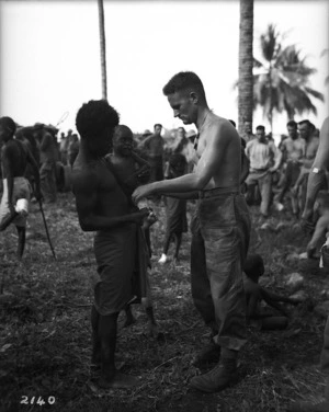 World War II New Zealand medical orderly treating locals, Nissan Island, Papua New Guinea