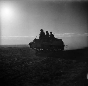 World War 2 soldiers on a dawn reconnaissance, travelling on a tank in the Western Desert, North Africa