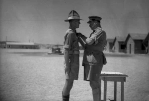 Major General L M Inglis presenting the Distinguished Conduct Medal to W J Smith at the New Zealand School of Instruction, Maadi, Egypt