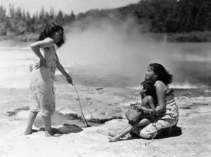 Unidentified Maori women and child group alongside a thermal spring