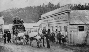 Coach, with passengers, alongside the Caledonian Hotel, Notown, Westland